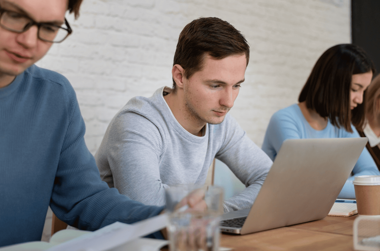 Participants suivant une formation en automatisation et workflow n8n sur ordinateur portable dans un environnement de travail collaboratif.