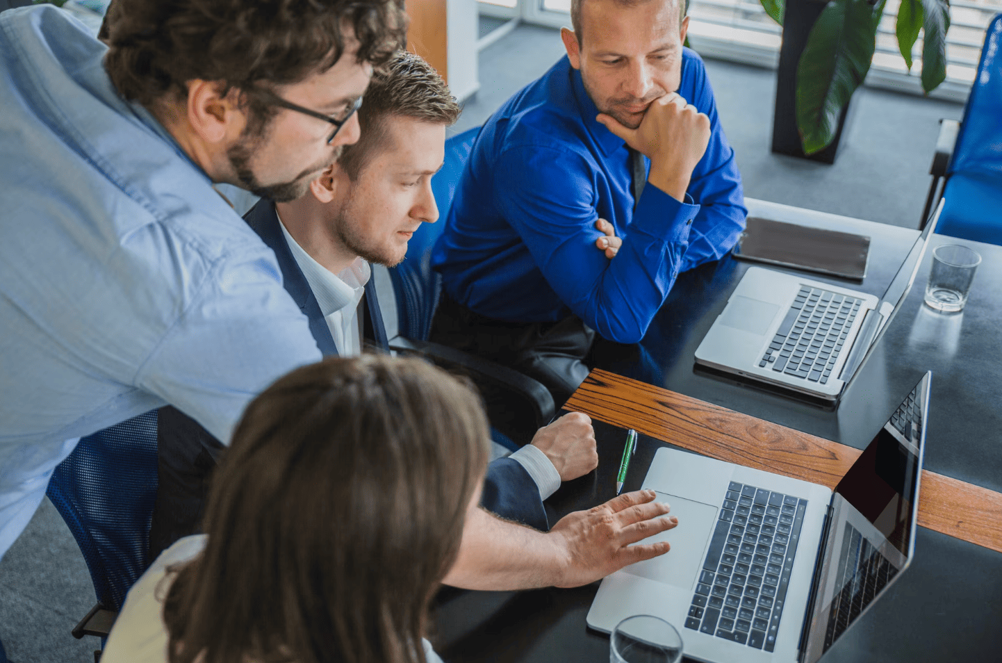 Professionnels collaborant autour d’un ordinateur portable lors d’une formation au développement assisté par IA et aux outils de code.